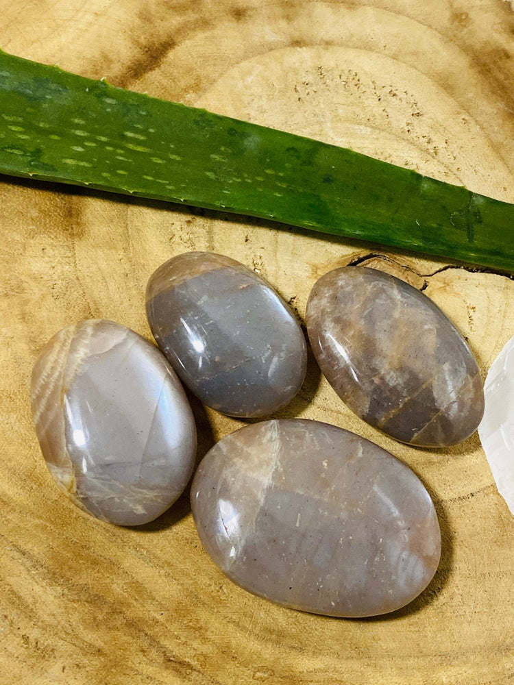 Mondstein Handschmeichler vier auf hölzerner Unterlage
