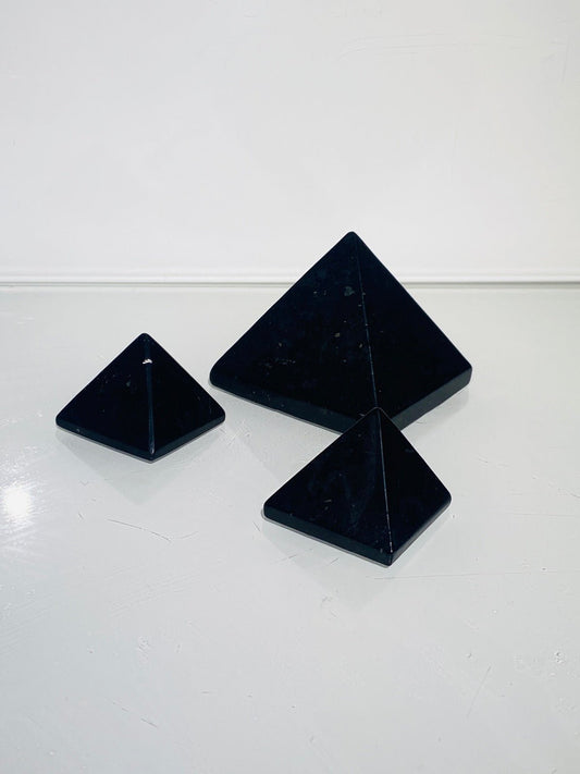 3 Stück schwarze Schungit Pyramiden in 3 - 5 cm auf weißem Hintergrund
