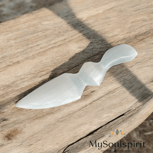 Selenit Dolch ca. 14,5 cm auf einem alten Holzbalken. Ein Selenit-Dolch ist ein weißer Kristalldolch mit einer faserigen Oberfläche.