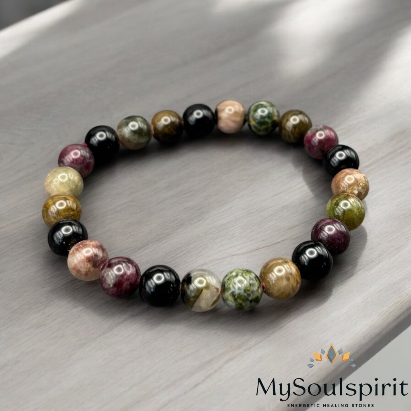 TURMALIN Multicolor Armband 4/6/8 mm Perlen auf einem Holztisch