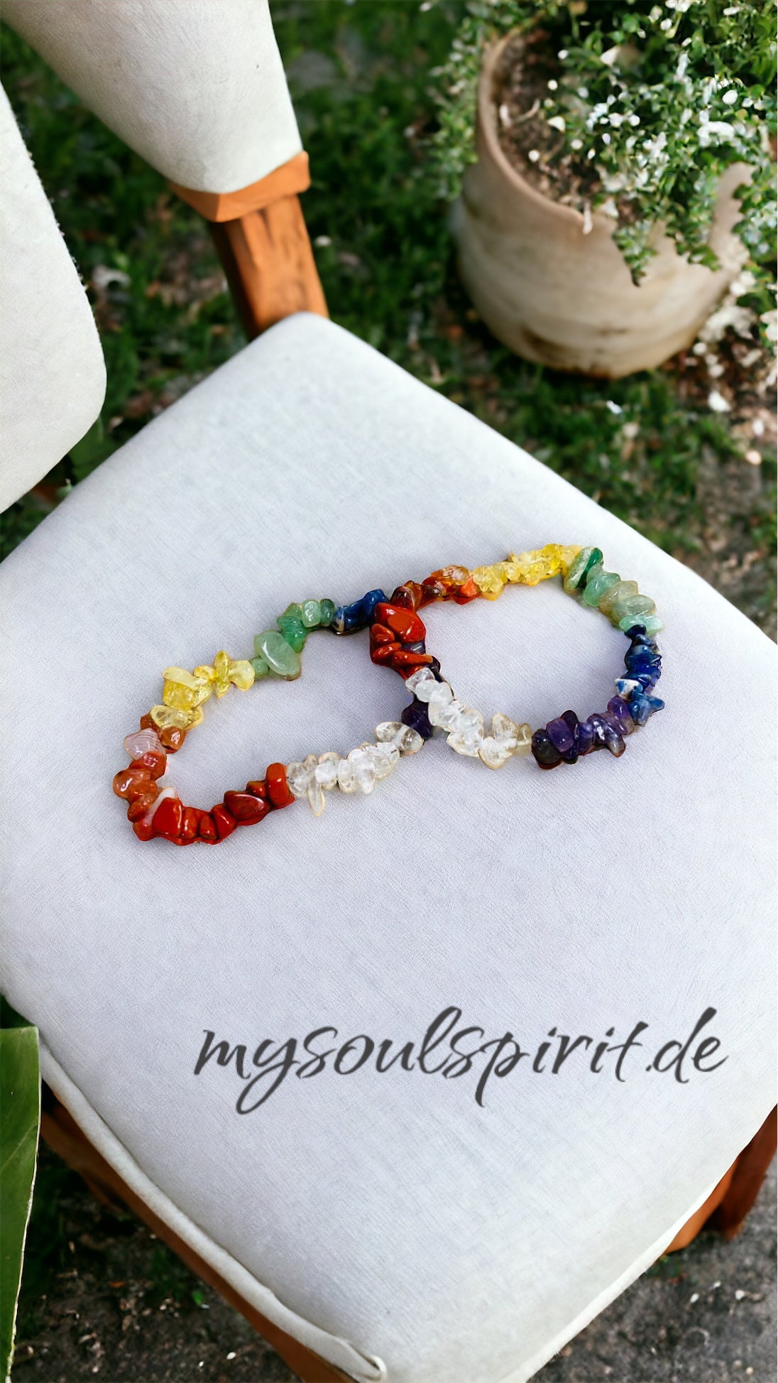 Chakra splitterarmband auf weißem sitzpolster 